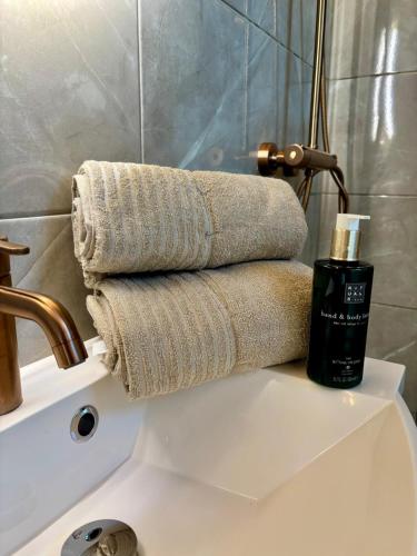 a pile of towels on top of a bathroom sink at Mystical Lapland Suite in Rovaniemi
