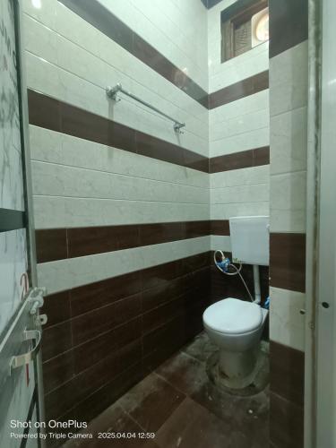 a bathroom with a toilet and brown and white stripes at Kaushlendra Bhawan in Ayodhya