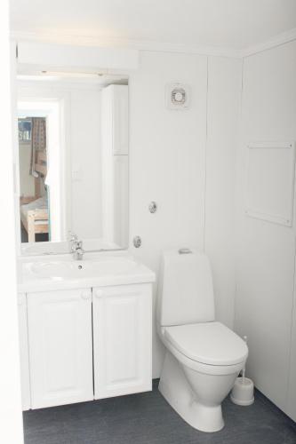 a white bathroom with a toilet and a sink at Rondaplassen in Kvam
