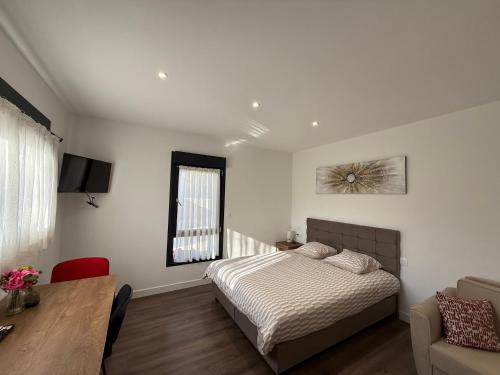 a bedroom with a bed and a table and a television at Le 6 by Montélimar in Montélimar