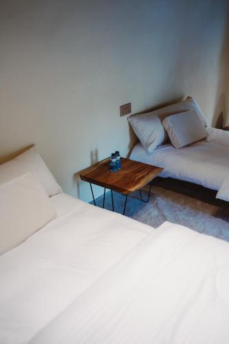 a room with two beds and a wooden table at Seet Room in Bilād Sayt