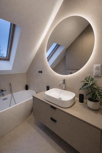 a bathroom with a sink and a tub and a mirror at Oaza Radęcin in Woldenberg Neumark