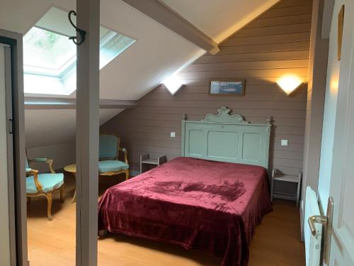 a bedroom with a red bed in a attic at Chalet Les Ammonites 2 chambres en Franche Comte au calme dans la nature in Nans-sous-Sainte-Anne
