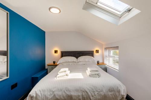a bedroom with a large bed with towels on it at Botanic Cottages in Southport