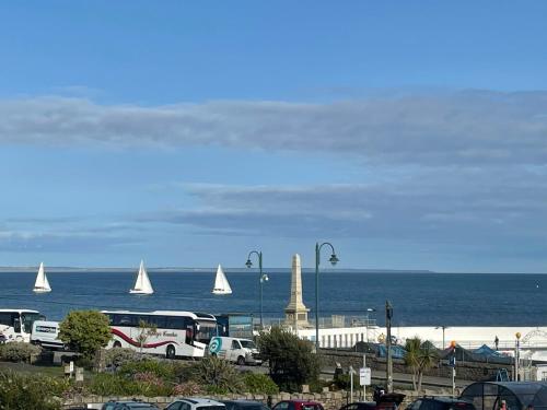 a parking lot with cars and sail boats in the water at Little Yacht Inn in Penzance