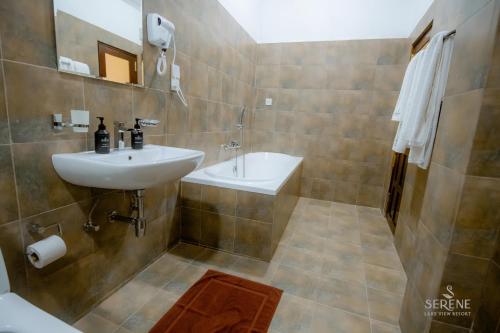 a bathroom with a sink and a toilet and a tub at Serene Lake View Resort in Anuradhapura