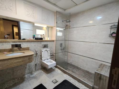 a bathroom with a toilet and a sink and a shower at Huge studio apartment with entire luxury villa acess in Ajman