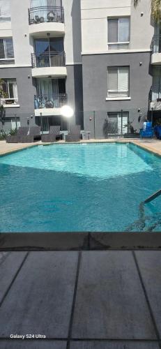 a large blue swimming pool in front of a building at Large two-room apartment near LAX and the Ocean in Los Angeles