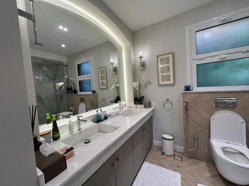 a bathroom with two sinks and a toilet at 2 Bedroom Villa with Private Pool in Ras al Khaimah