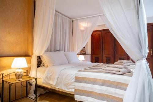 a bedroom with a large white bed with curtains at Villa BALRA une maison d'hôtes au coeur du centre ville in Rabat