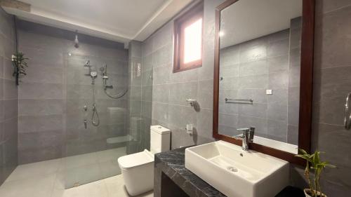 a bathroom with a sink and a shower and a toilet at Mollusca Beach Villa in Waskaduwa