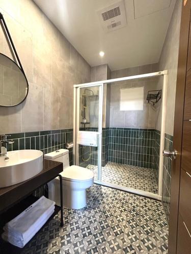 a bathroom with a shower and a toilet and a sink at Yutian B&B in Zhuangwei