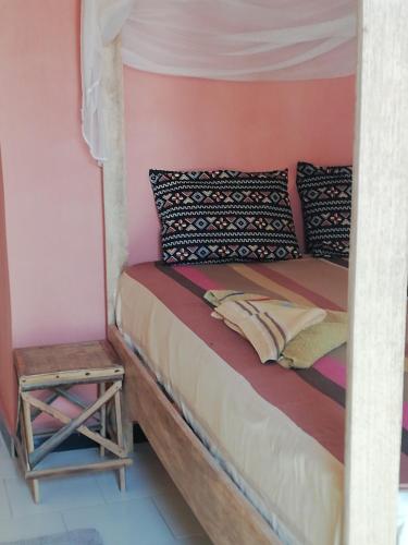 a bed in a room with a side table at Maison Manour Studio 4 personen in Mbour