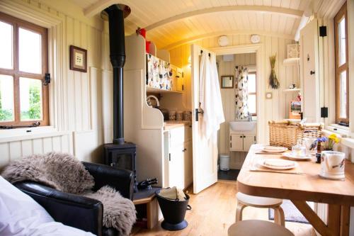a kitchen with a table and a stove in a room at Morndyke Shepherds Huts in Thirsk