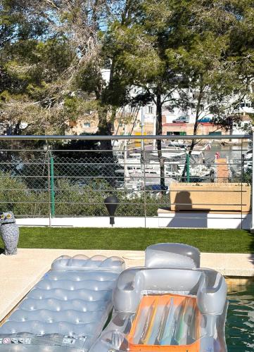 a group of chairs sitting next to a body of water at Chalet Barceló Rocher in Cala d´Or