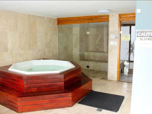 a bath tub in a bathroom with a shower at Grande Hotel in Cape Town