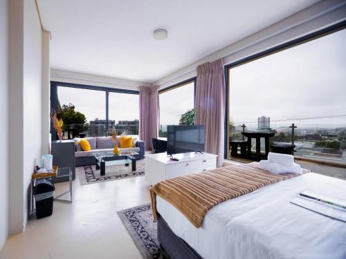a bedroom with a large bed and a large window at Grande Hotel in Cape Town
