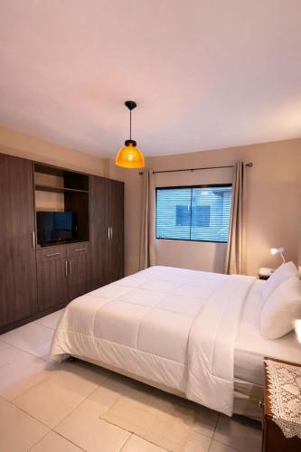 una camera da letto con un grande letto bianco e due finestre di Mandala Apartments a Luque