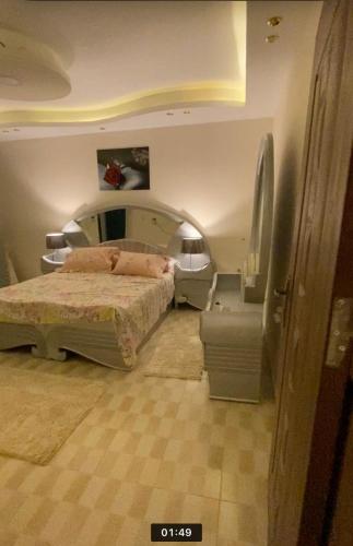 a bedroom with a bed and a chair in it at horizon sky pyramids in Cairo