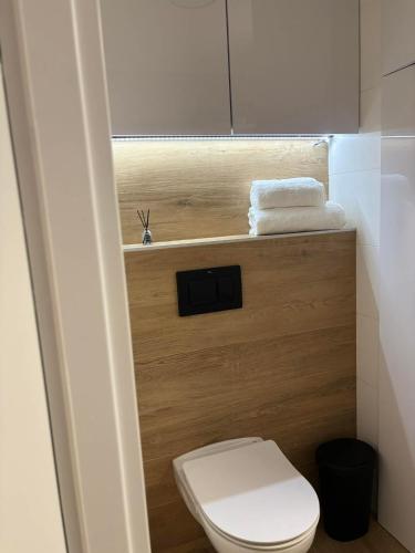 a small bathroom with a white toilet and towels at The Gold Resident Airport Warszawa-Modlin in Nowy Dwór Mazowiecki