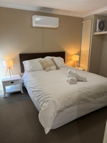 a bedroom with a large white bed with two lamps at Sea Renity Preston Beach in Preston Beach