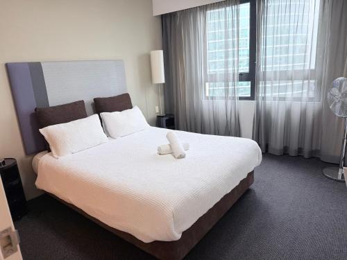 a bedroom with a bed with a teddy bear on it at 1 Bedroom Apartment In the heart of Parramatta CBD in Sydney