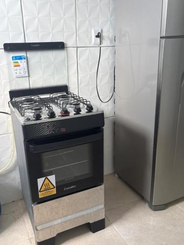 a stove in a kitchen next to a refrigerator at The Brooklyn One in Salvador