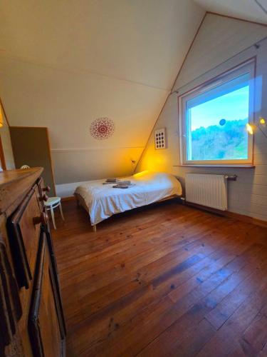 a bedroom with a bed and a large window at Camembert & Crustacés in Veulettes-sur-Mer