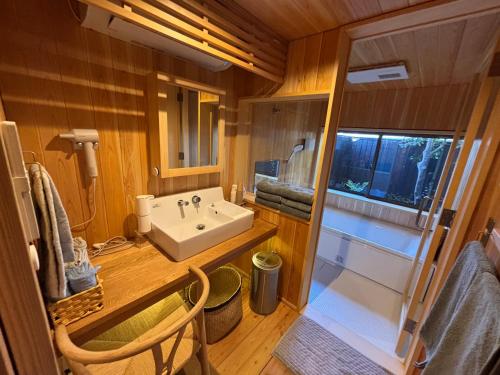 a small bathroom with a sink and a window at 離れの宿 かぶろの庭 離れの宿 KuRA in Matsukawa