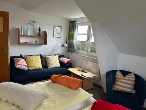 a living room with a couch and a bed at Zum Fahrensmann in Norddorf