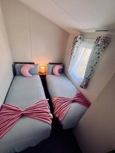 two beds in a small room with a window at B17 SilverSands Escape in Lossiemouth