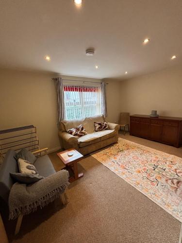 a living room with a couch and a chair at The Cozy Covert in Spondon, Derby in Derby