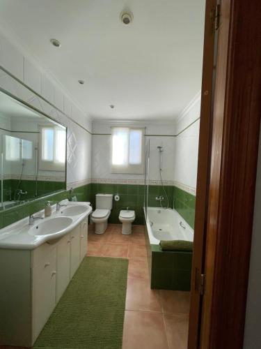 a bathroom with two sinks and a tub and toilet at Ca Ona in Chella