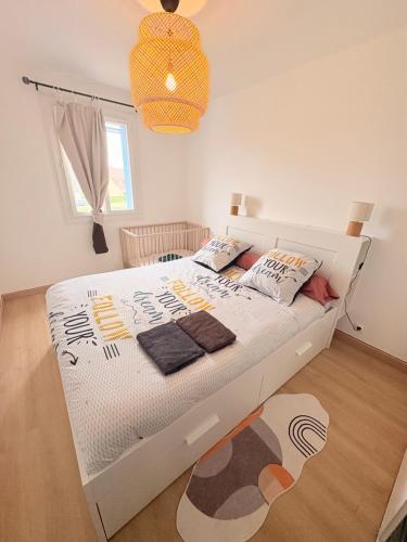 a bedroom with a white bed with pillows on it at Le cocon auvergnat in Lapalisse