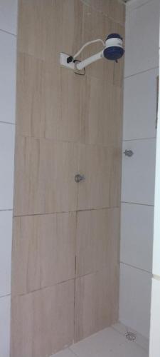 a shower with a wooden wall in a bathroom at Kitnet na Imbiribeira in Recife