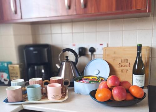 a kitchen counter with a bowl of fruit and a bottle of wine at Nice relaxing apartment in Mandria, in Mandria