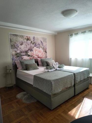 a bedroom with a bed with a painting on the wall at Apartmani Marijana in Lozovac