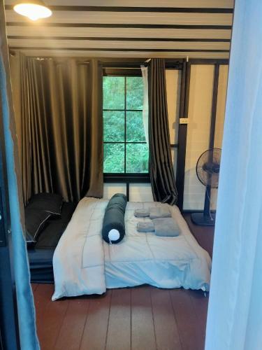 a large bed in a room with a window at Ingphai Homestay in Suratthani