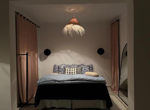 a bedroom with a bed and a pendant light at Cozy Sousse Studio in Hammam Sousse
