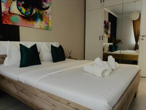 a bedroom with a large white bed with towels on it at Adam Residence in Oradea