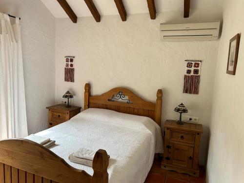 a bedroom with a wooden bed and two night stands at Casa Olivo in Casarabonela