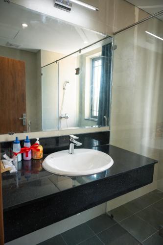 a bathroom counter with a sink and a mirror at Khách Sạn The Sum in Tây Ninh