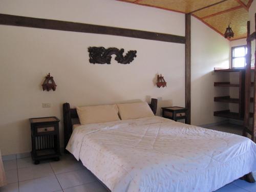 sypialnia z białym łóżkiem i 2 szafkami nocnymi w obiekcie XPai w mieście Pai