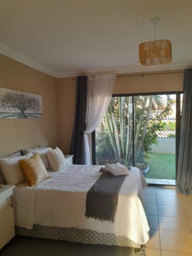 a bedroom with a bed and a large window at Guesthouse at 543 in Lebowakgomo