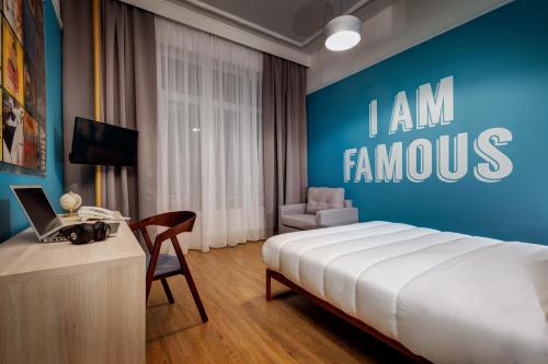 a bedroom with a bed and a desk with a laptop at Colors Urban Hotel Thessaloniki in Thessaloniki