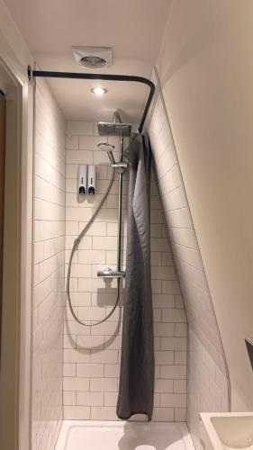 a shower with a hose in a bathroom at Barbican Boutique Luxury Apartments & Rooms, Plymouth in Plymouth