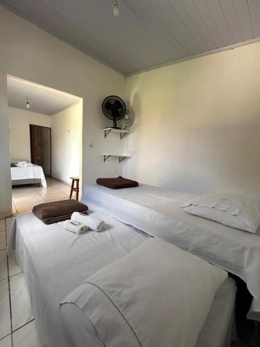 a bedroom with two white beds and a room with a bed at Hospedagem Portal da Terra in São João