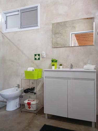 a bathroom with a sink and a toilet and a mirror at Basaltic Guest House in Achadinha