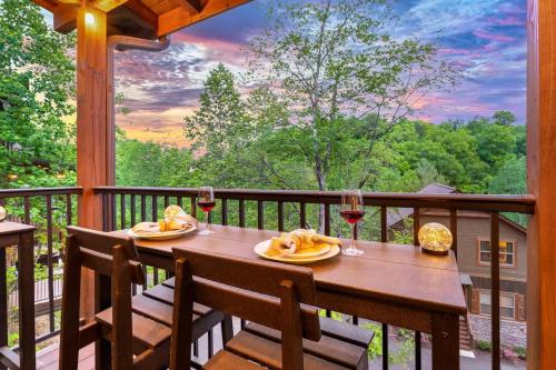 a table on a balcony with two glasses of wine at Ridgetop Hideaway in Pigeon Forge