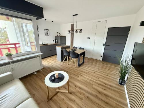 a living room with a table and a kitchen at Terrassenhaus, FeWo 45 in Duhnen